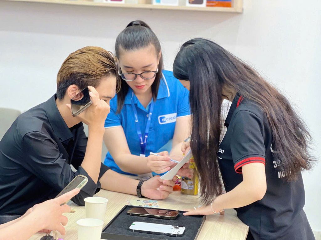 Nhân viên Táo 247 phối hợp cùng chuyên viên Mcredit hỗ trợ khách hàng làm hồ sơ trả góp iPhone ngay tại cửa hàng