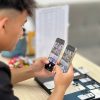 Khách hàng đang kiểm tra kỹ iPhone cũ trước khi mua tại cửa hàng Táo 247 Đà Nẵng