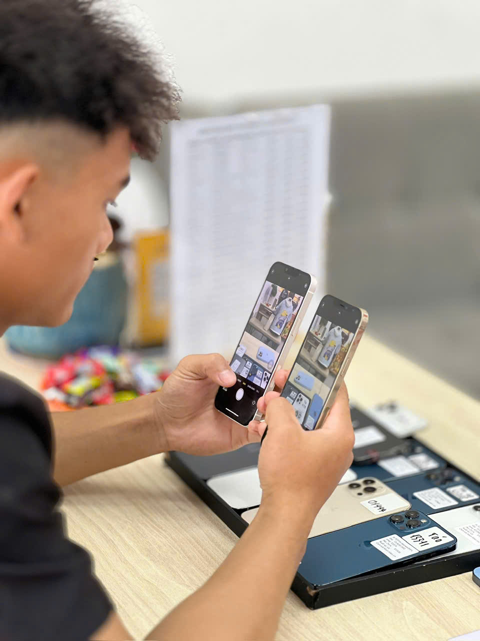 Khách hàng đang kiểm tra kỹ iPhone cũ trước khi mua tại cửa hàng Táo 247 Đà Nẵng