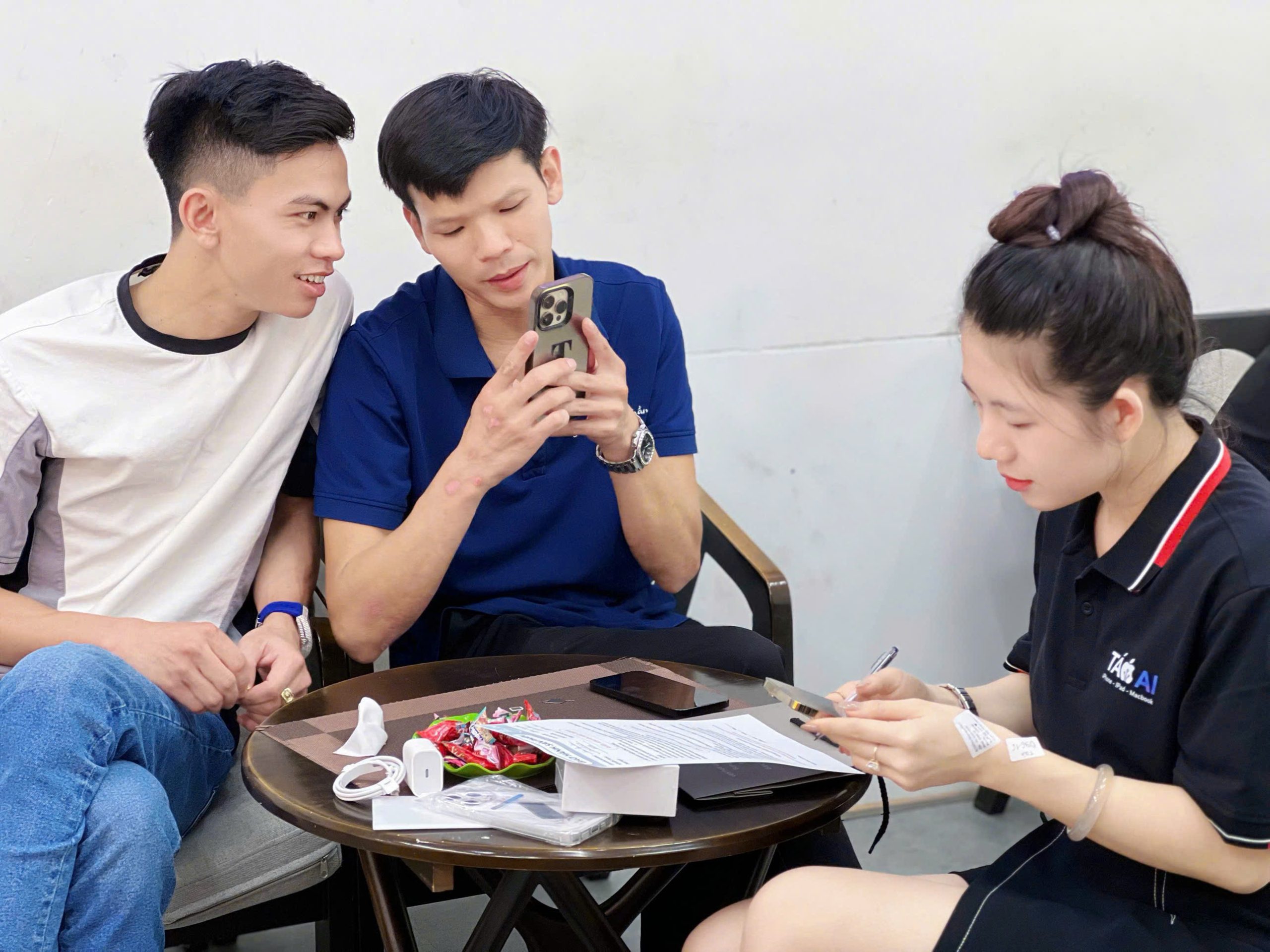 Khách hàng nhận iPhone 11 cũ và ký giấy bảo hành tại cửa hàng Táo 247 Đà Nẵng