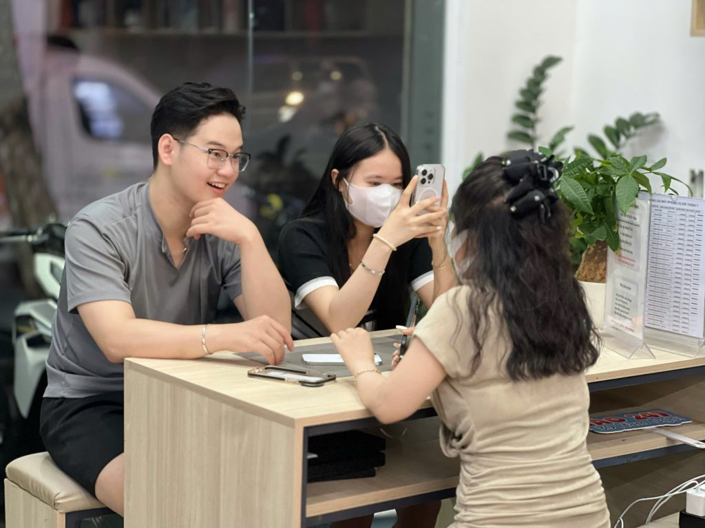 Khách hàng kiểm tra iPhone 14 Pro cũ cùng nhân viên tại Táo 247 Đà Nẵng