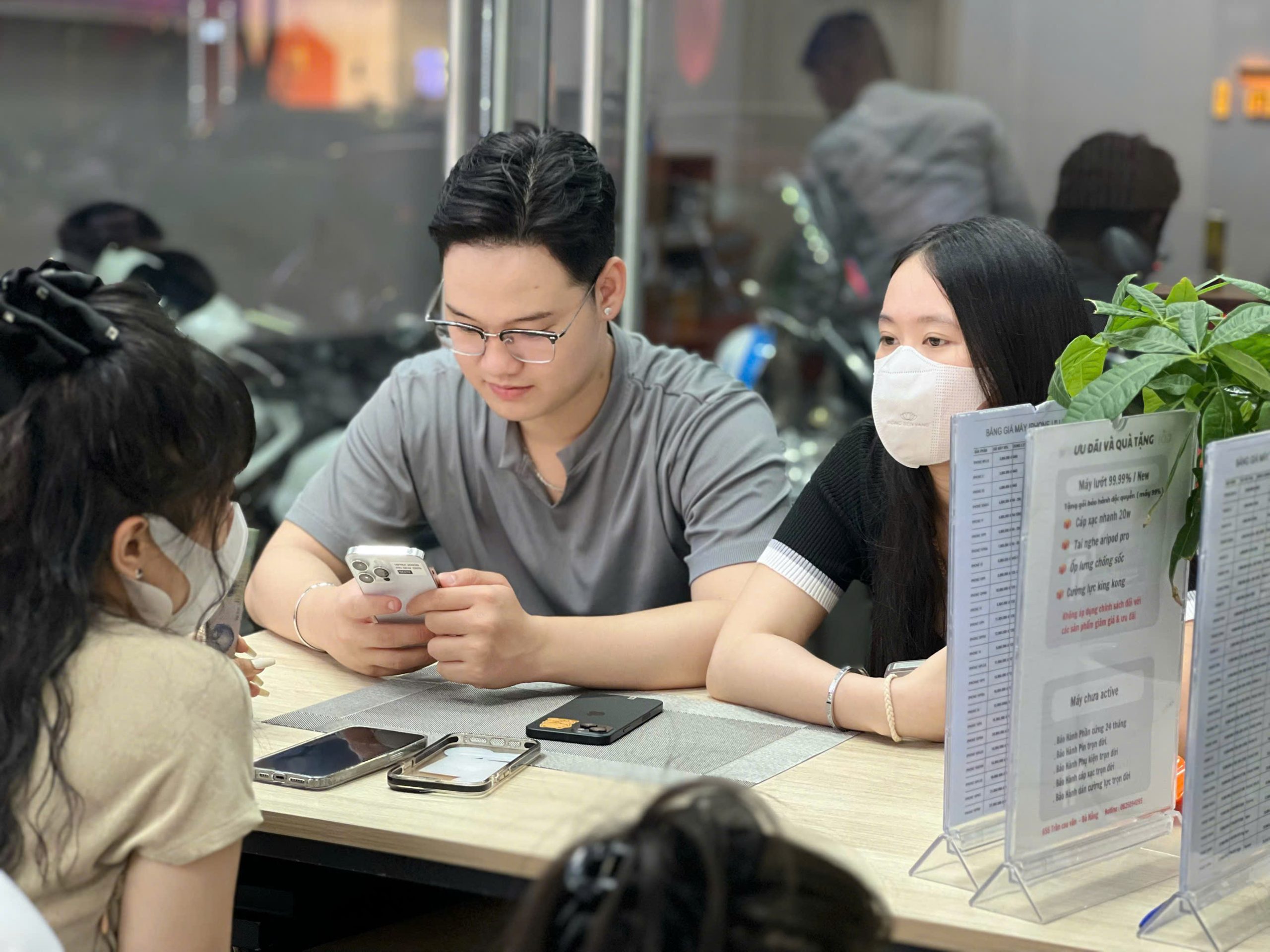 Khách hàng đôi kiểm tra iPhone 14 Pro cũ tại cửa hàng Táo 247 Đà Nẵng trước khi quyết định mua
