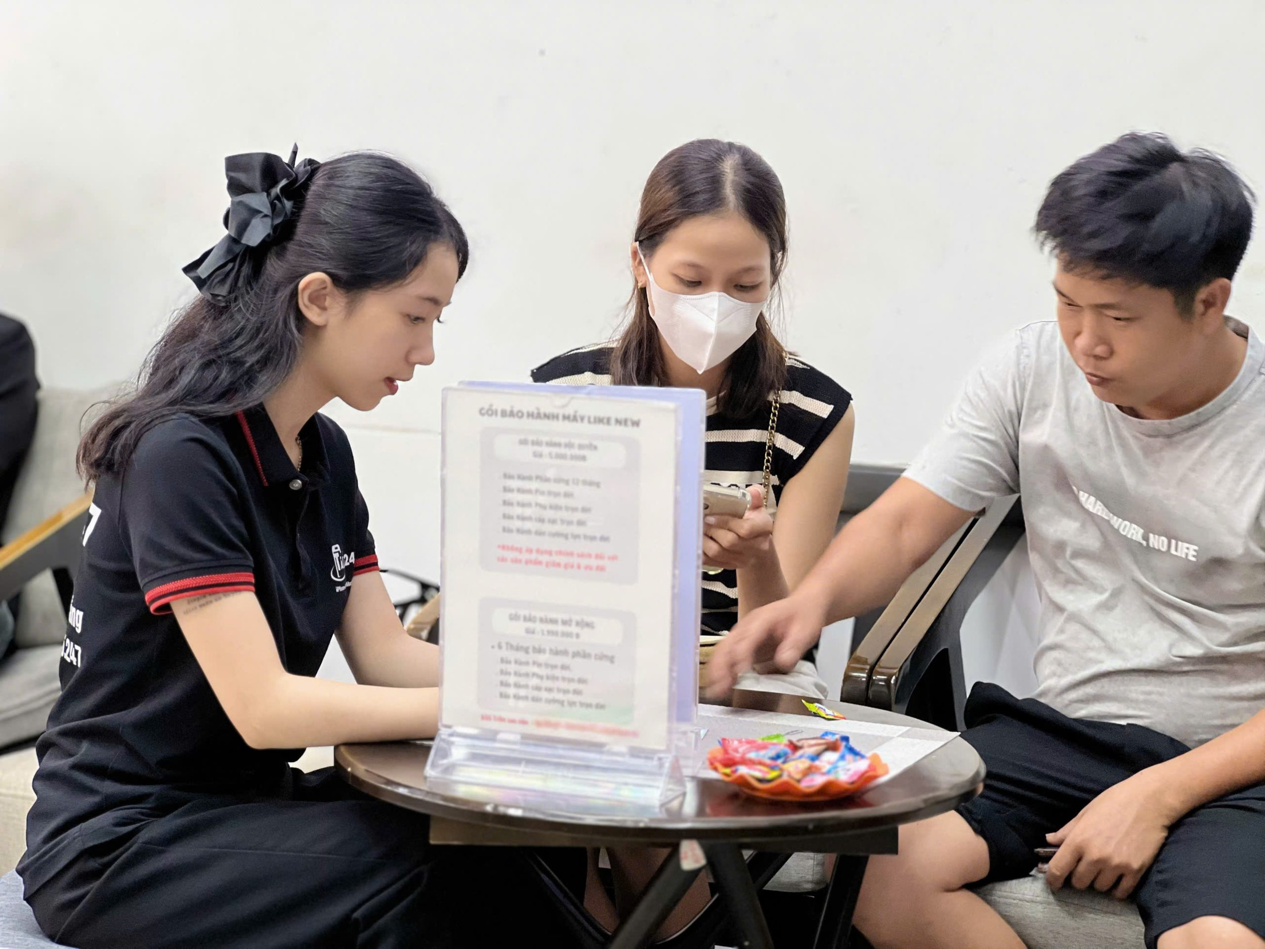 Nhân viên Táo 247 tư vấn chính sách bảo hành iPhone cũ cho khách hàng tại cửa hàng Đà Nẵng