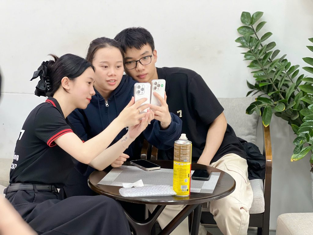 Nhân viên Táo 247 hướng dẫn khách hàng so sánh iPhone 15 Pro Max cũ tại cửa hàng Đà Nẵng
