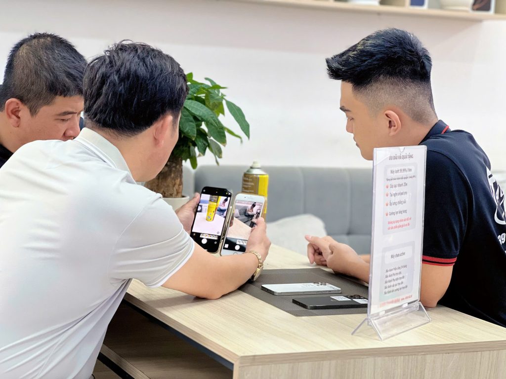Khách hàng test iPhone cũ cùng nhân viên tại Táo 247 Đà Nẵng