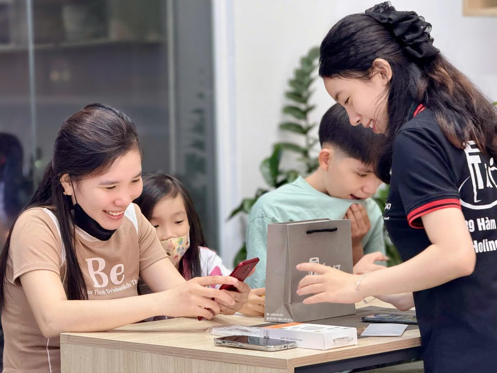 Khách hàng hài lòng khi nhận iPhone cũ giá rẻ tại Táo 247 – không khí vui vẻ, thân thiện