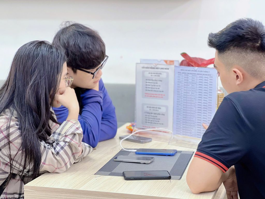 Nhân viên Táo 247 tư vấn chính sách và bảng giá iPhone like new cho khách hàng tại cửa hàng Đà Nẵng
