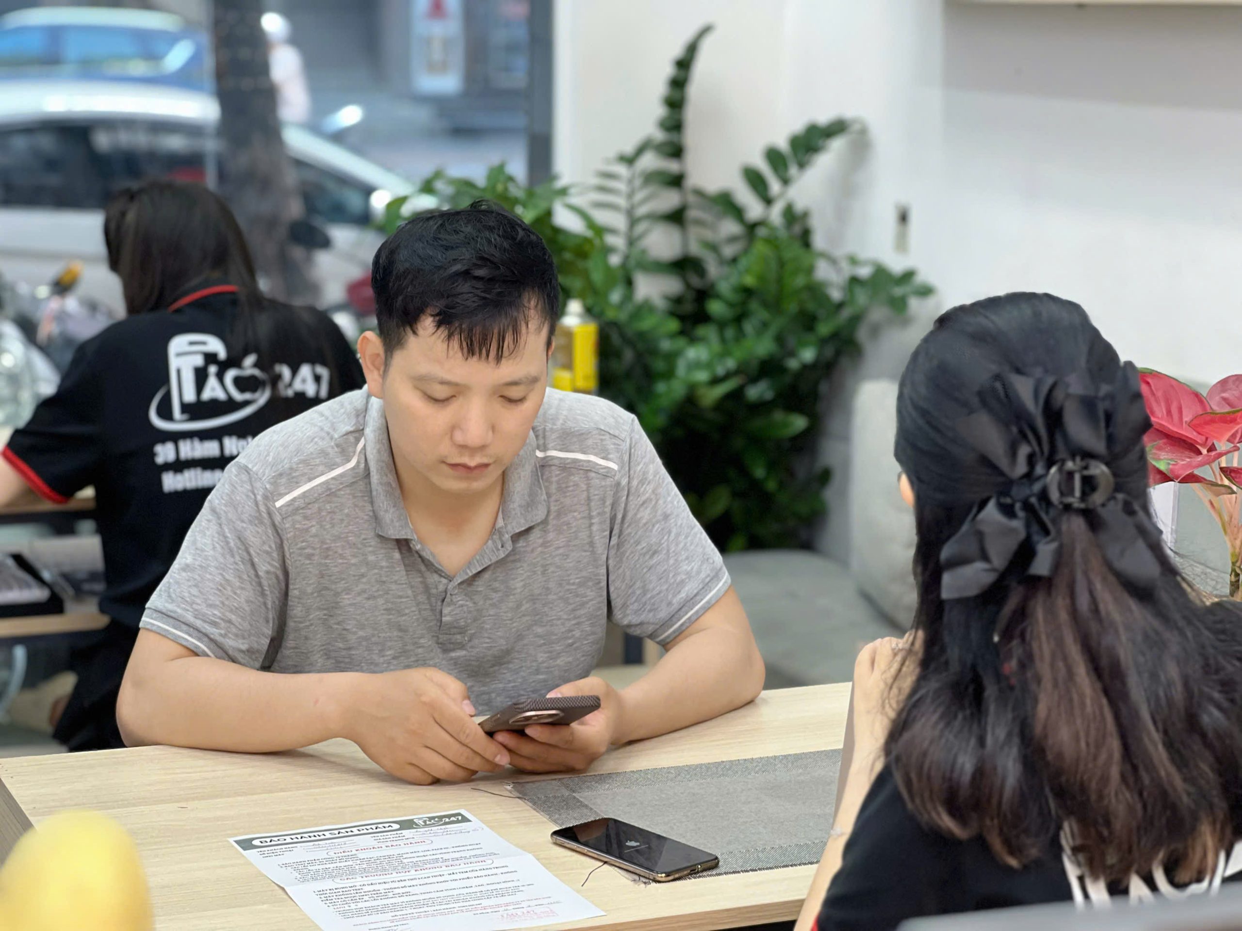 Khách hàng kiểm tra iPhone và làm thủ tục mua máy tại Táo 247 Đà Nẵng