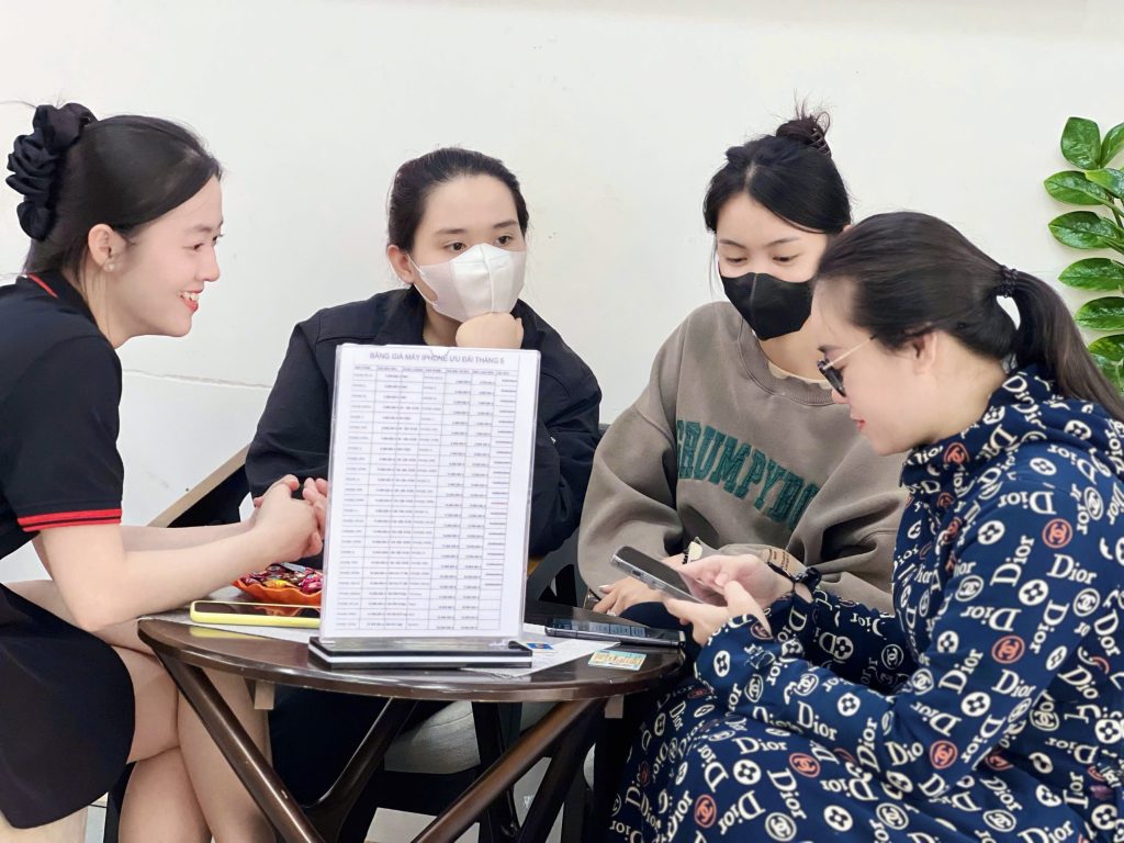 Khách hàng nữ xem bảng giá iPhone 13 Pro Max cũ tại cửa hàng Táo 247 Đà Nẵng