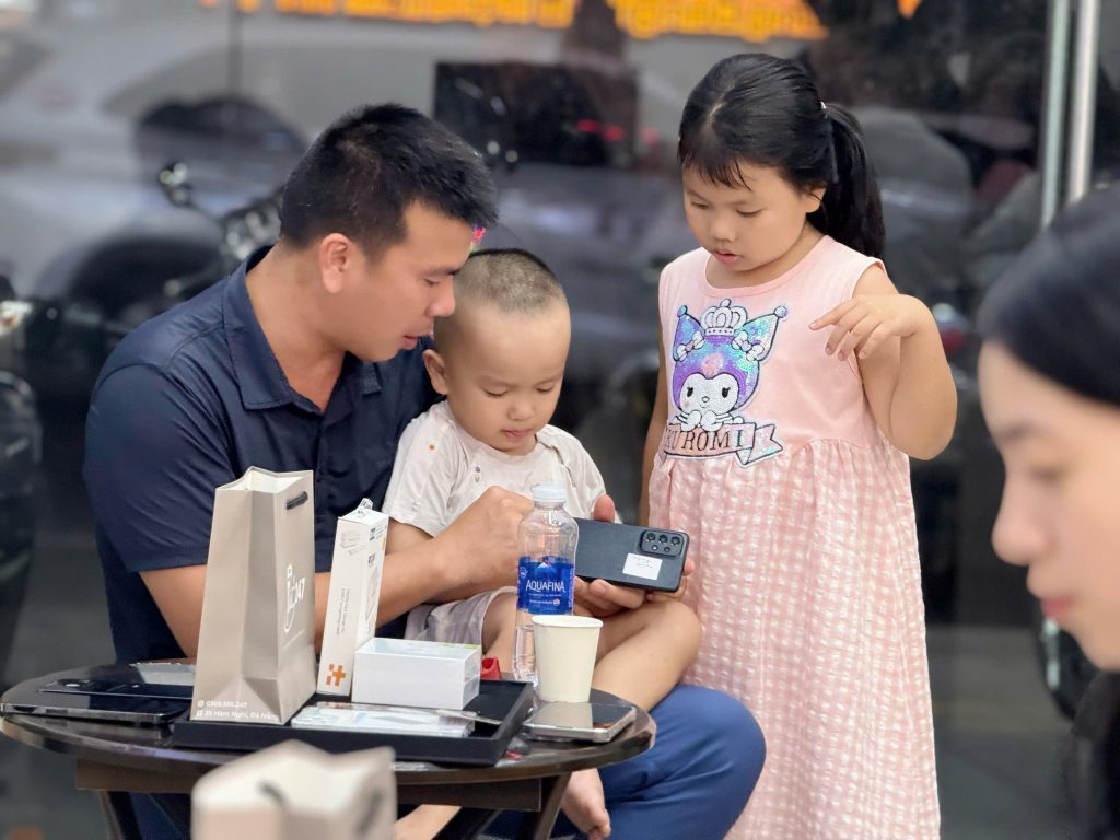 Khách hàng cùng gia đình trải nghiệm iPhone cũ tại Táo 247 Đà Nẵng – Không gian thân thiện, dịch vụ tận tâm