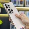 Hai chiếc iPhone cũ Pro màu vàng với camera đẹp được cầm trên tay tại cửa hàng ở Đà Nẵng.