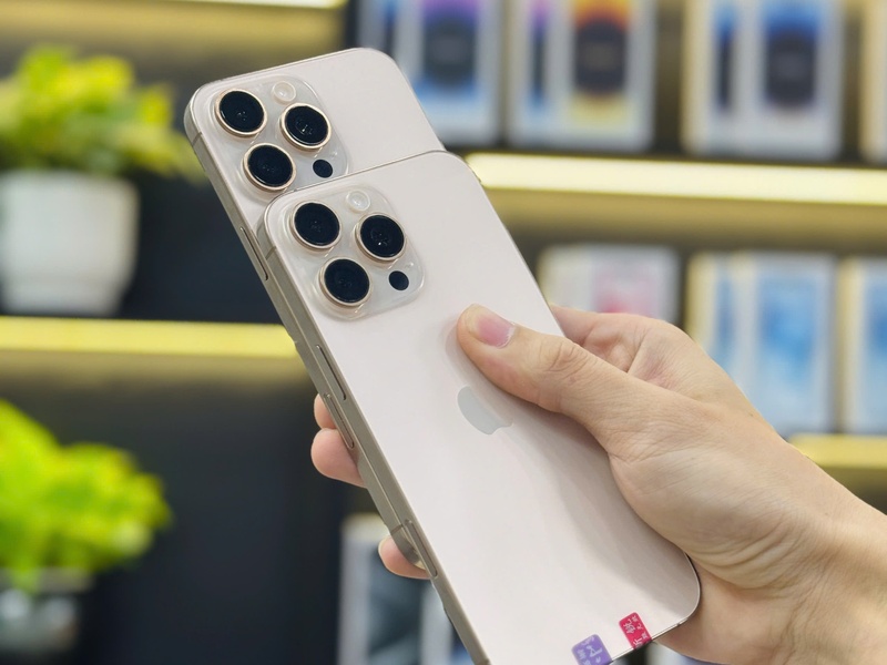 Hai chiếc iPhone cũ Pro màu vàng với camera đẹp được cầm trên tay tại cửa hàng ở Đà Nẵng.