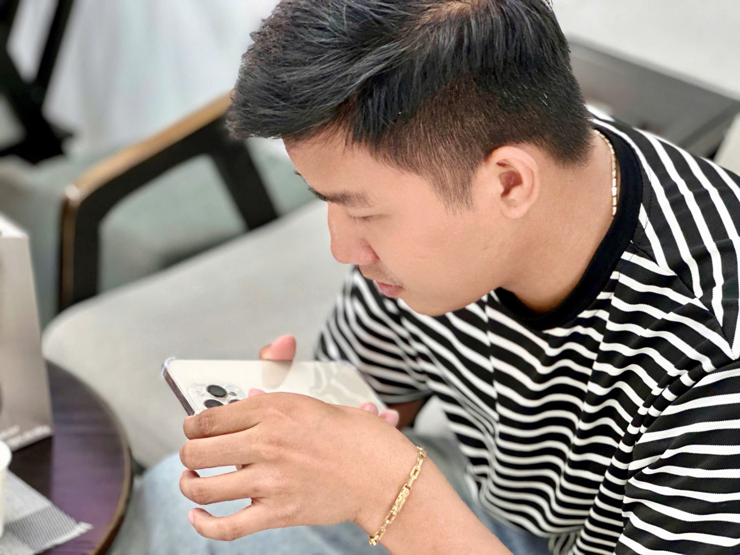 Khách hàng nam kiểm tra iPhone cũ kỹ lưỡng trước khi mua tại Táo 247 Đà Nẵng