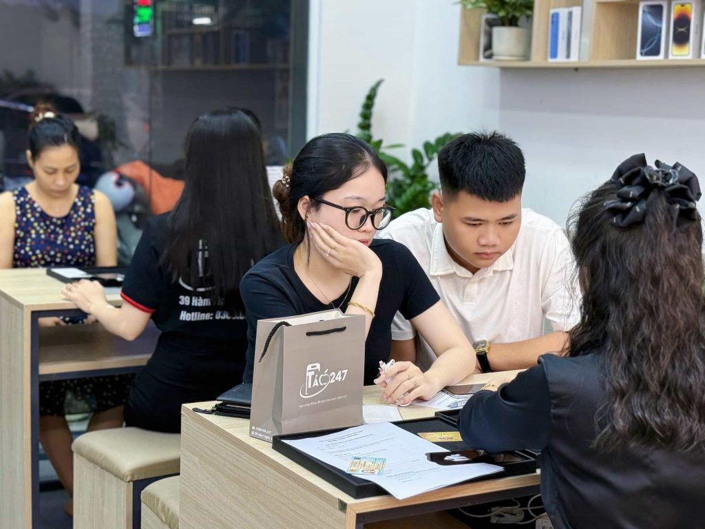 Nhân viên Táo 247 iPhone Đà Nẵng tư vấn iPhone cũ cho khách hàng tại cửa hàng