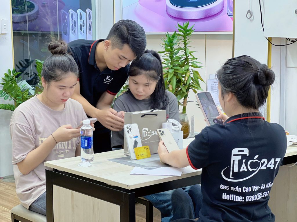Nhân viên Táo 247 Đà Nẵng hỗ trợ khách hàng kiểm tra iPhone cũ