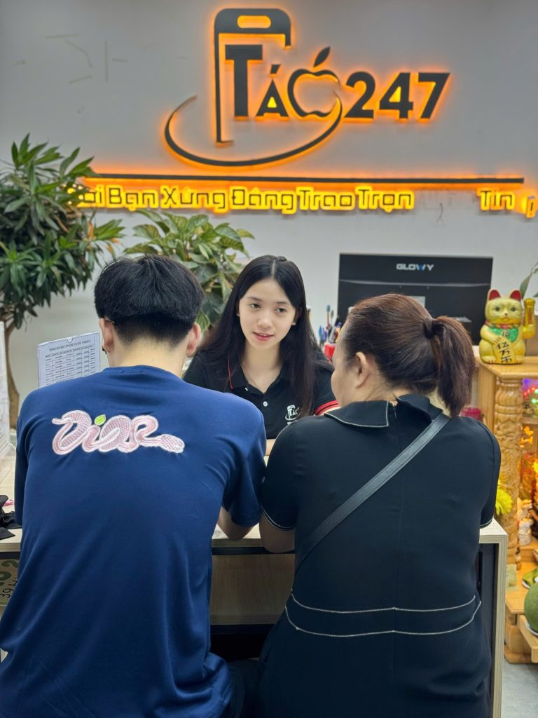 Nhân viên Táo 247 tư vấn khách mua iPhone cũ 7–10 triệu tại quầy lễ tân Đà Nẵng
