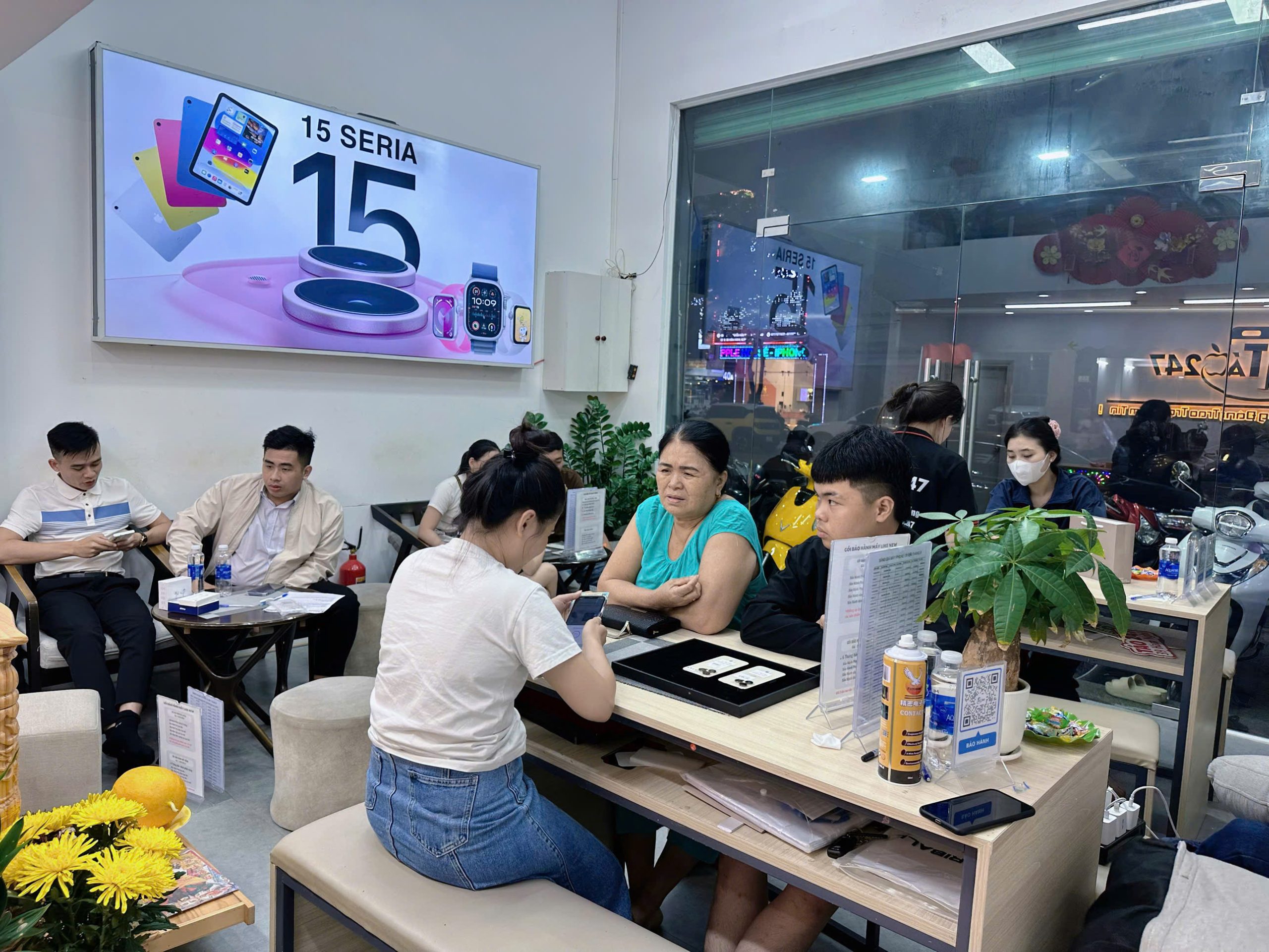 Khách hàng được tư vấn chọn iPhone cũ tại Táo 247 Đà Nẵng vào buổi tối