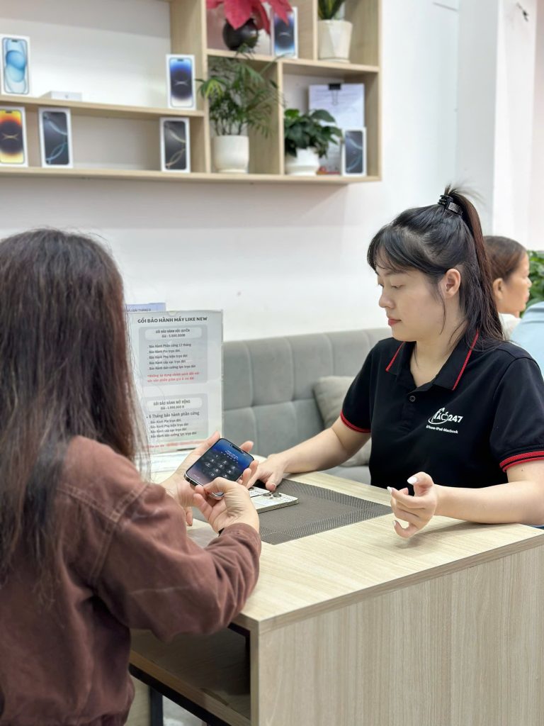 Nhân viên Táo 247 hỗ trợ khách hàng kiểm tra iPhone 256GB cũ tại Đà Nẵng
