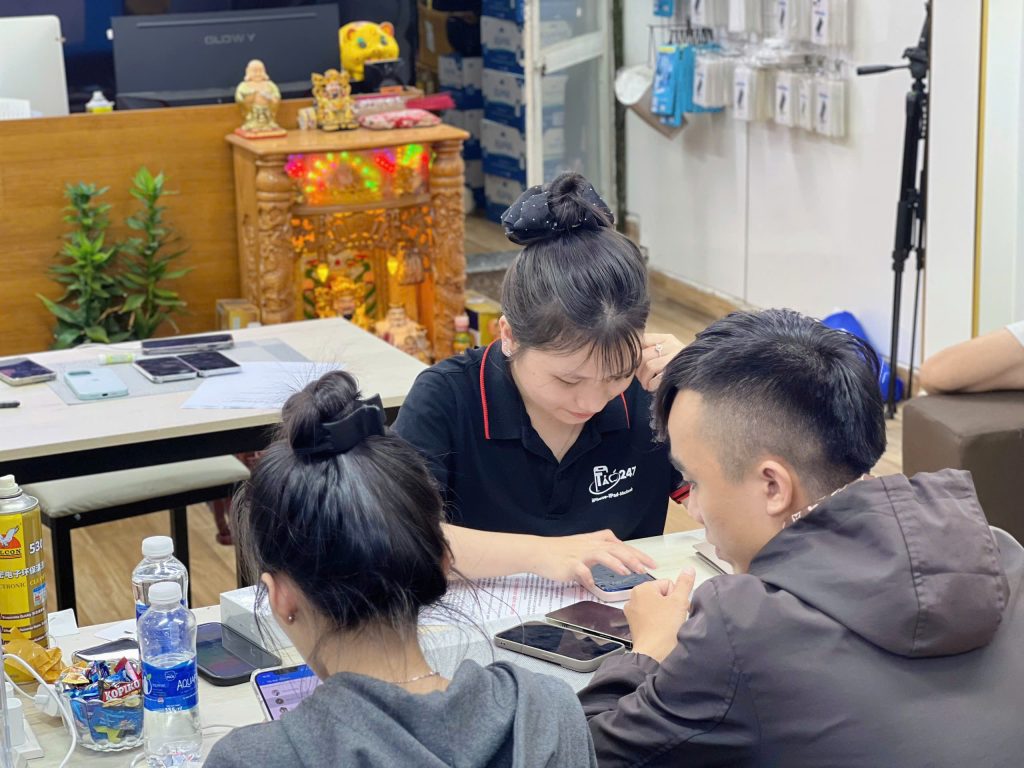 Nhân viên Táo 247 Đà Nẵng hỗ trợ khách hàng cài đặt iPhone cũ sau khi mua
