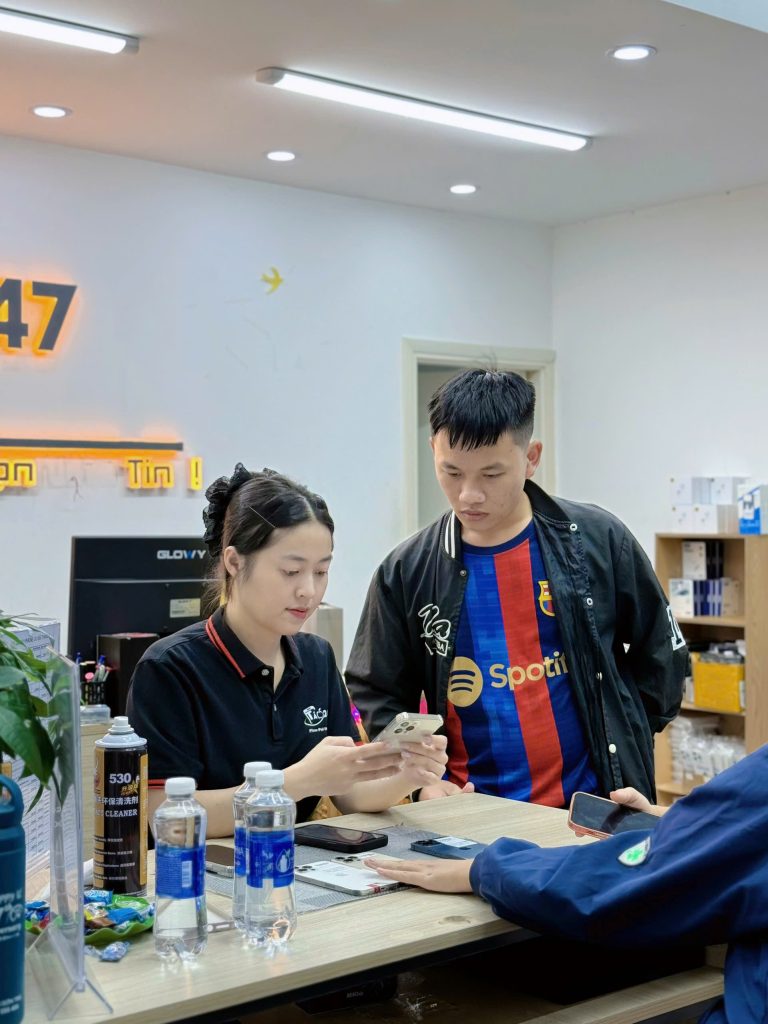 Nhân viên Táo 247 hướng dẫn khách hàng trải nghiệm iPhone cũ tại Đà Nẵng
