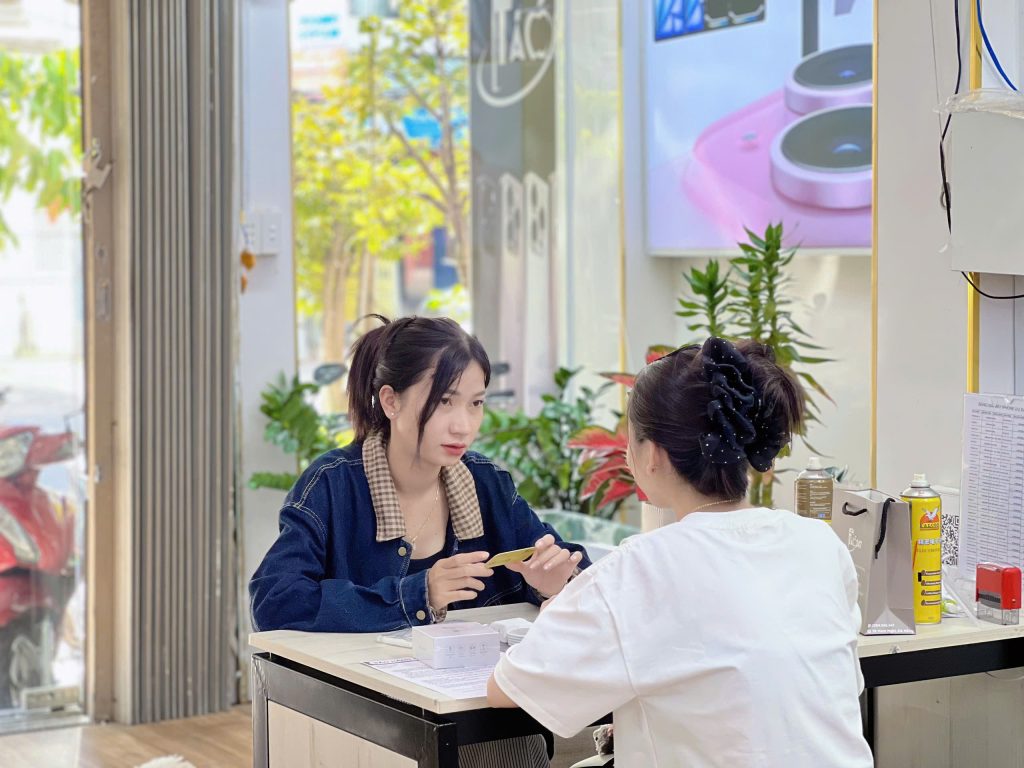 Khách hàng nữ được tư vấn chọn iPhone cũ bộ nhớ lớn tại cửa hàng Táo 247 Đà Nẵng