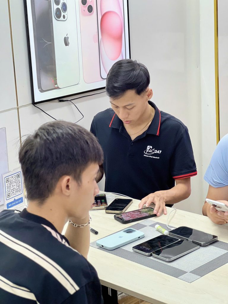 Nhân viên Táo 247 hỗ trợ khách kiểm tra iPhone cũ bộ nhớ lớn tại Đà Nẵng
