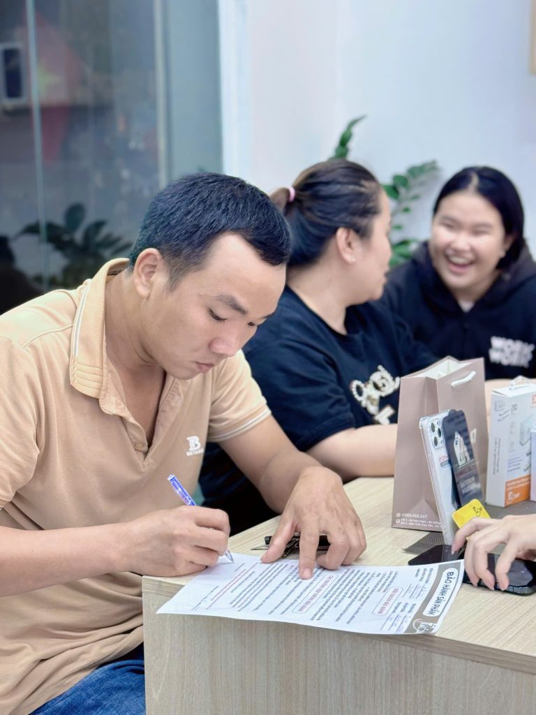 Khách hàng ký giấy mua iPhone cũ tại cửa hàng Táo 247 Đà Nẵng
