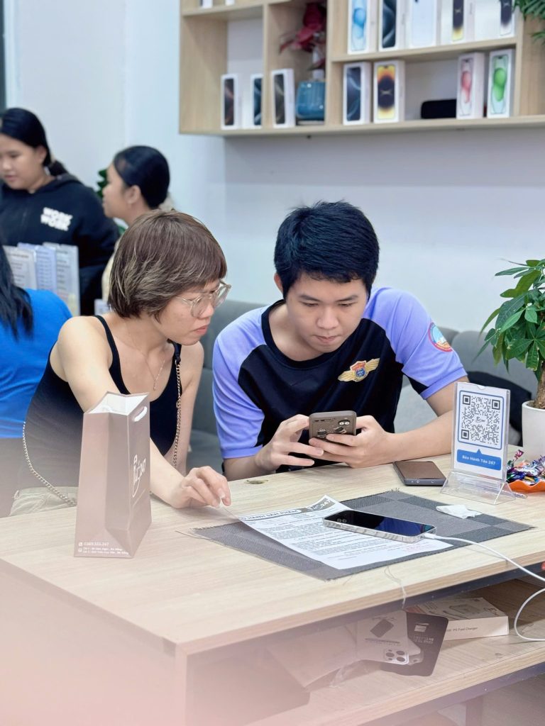 Khách hàng kiểm tra chính sách bảo hành khi mua iPhone cũ tại Táo 247 Đà Nẵng