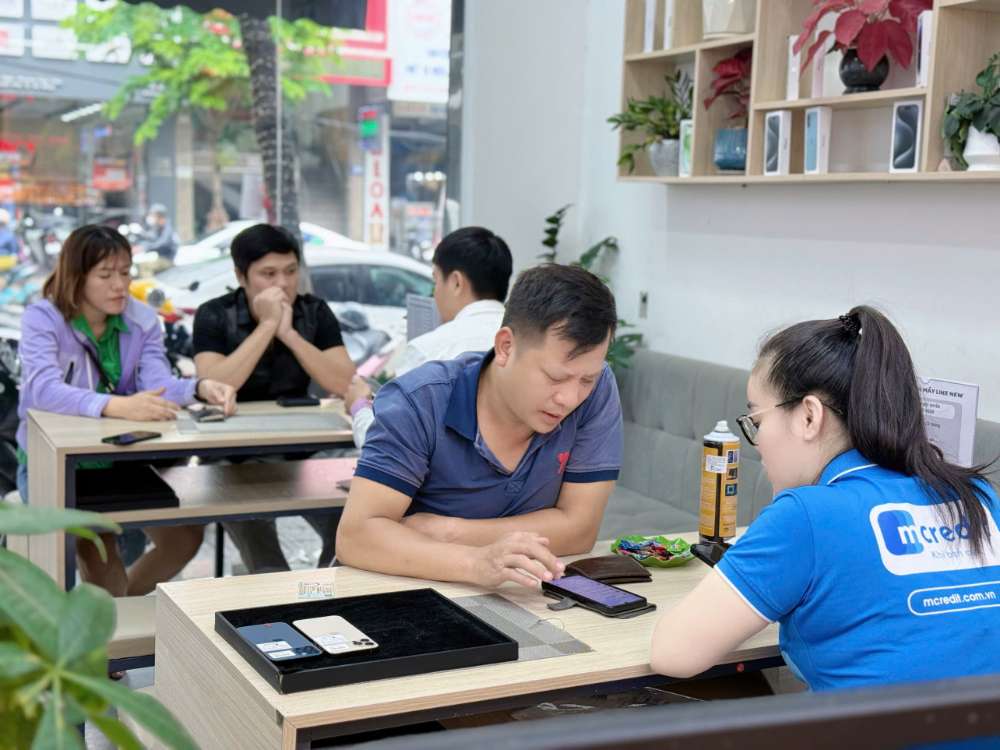 khách hàng được nhân viên Táo 247 Hồ Chí Minh tư vấn khi mua iPhone cũ
