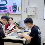 Nhân viên Táo 247 Hồ Chí Minh hỗ trợ khách hàng kiểm tra iPhone cũ trước khi mua