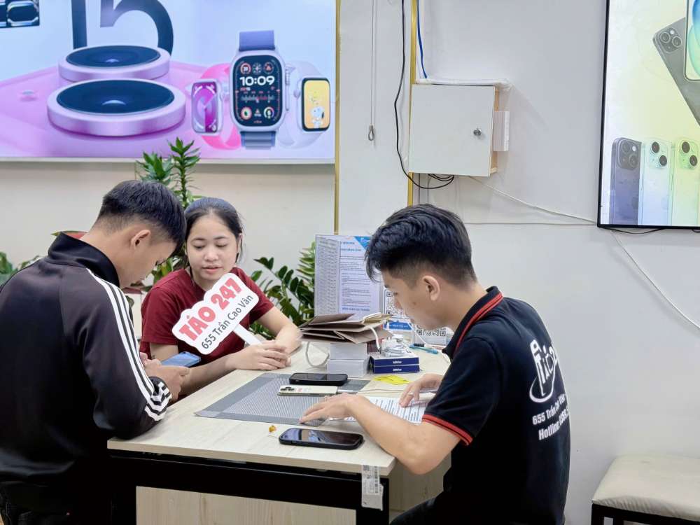 Nhân viên Táo 247 Hồ Chí Minh hỗ trợ khách hàng kiểm tra iPhone cũ trước khi mua