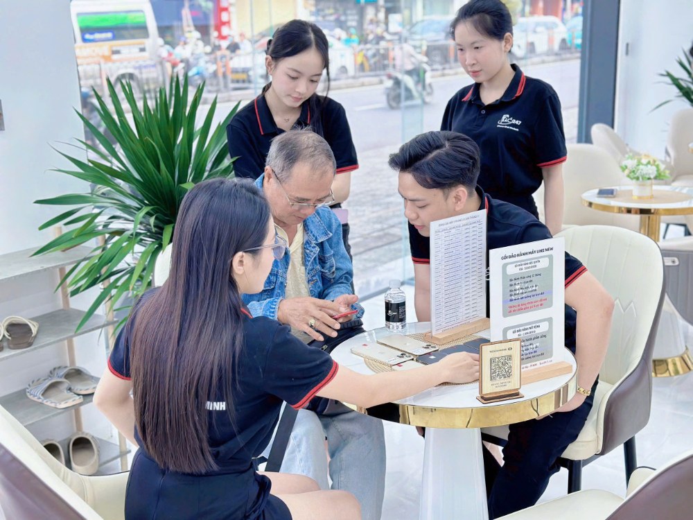 Nhân viên Táo 247 Hồ Chí Minh kiểm tra iPhone cũ cho khách hàng tại cửa hàng Gò Vấp