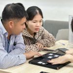 Nhân viên Táo 247 Hồ Chí Minh hướng dẫn khách hàng kiểm tra iPhone cũ trước khi mua – đảm bảo máy zin, không dựng