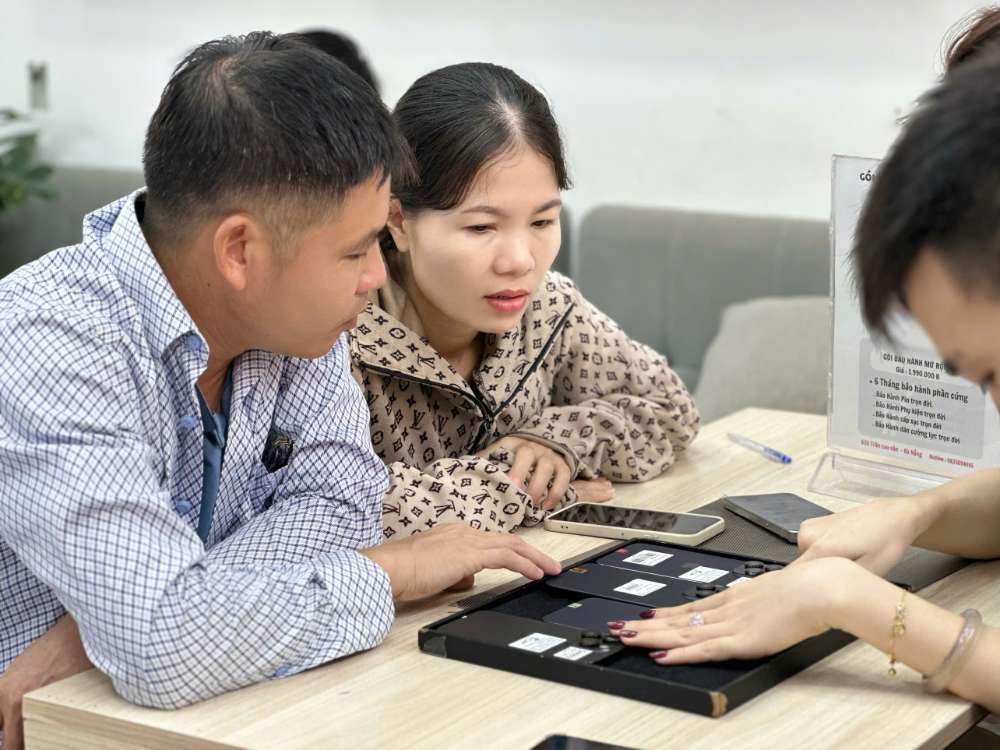 Nhân viên Táo 247 Hồ Chí Minh hướng dẫn khách hàng kiểm tra iPhone cũ trước khi mua – đảm bảo máy zin, không dựng