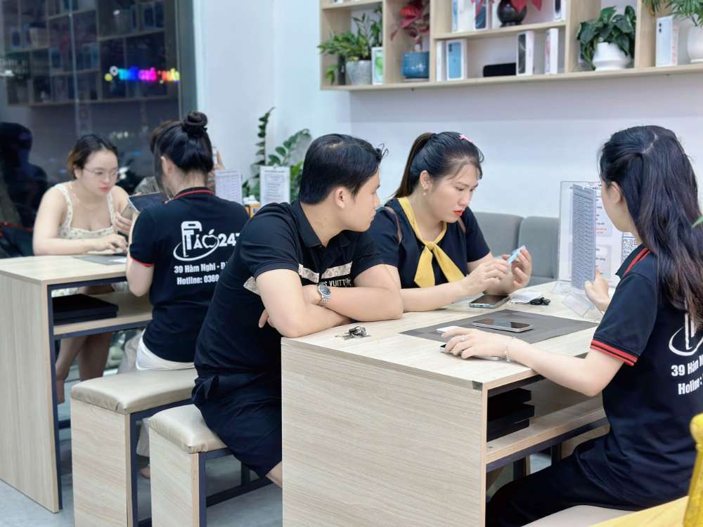 Khách hàng được nhân viên Táo 247 Hồ Chí Minh tư vấn chọn mua iPhone cũ – máy zin, giá tốt, bảo hành dài hạn