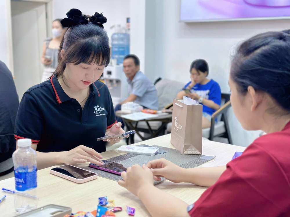 Nhân viên Táo 247 Hồ Chí Minh hỗ trợ khách test iPhone cũ chính hãng tại cửa hàng Gò Vấp