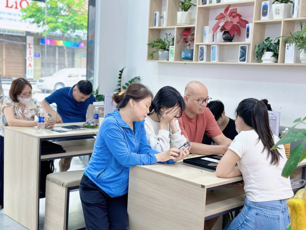 Khách hàng xem và kiểm tra iPhone cũ xách tay giá rẻ tại cửa hàng Táo 247 Hồ Chí Minh