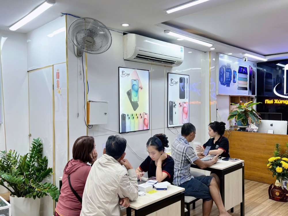 Nhân viên Shop Táo 247 Hồ Chí Minh tư vấn khách hàng kiểm tra và chọn mua iPhone cũ zin 100% tại Gò Vấp, TP.HCM.