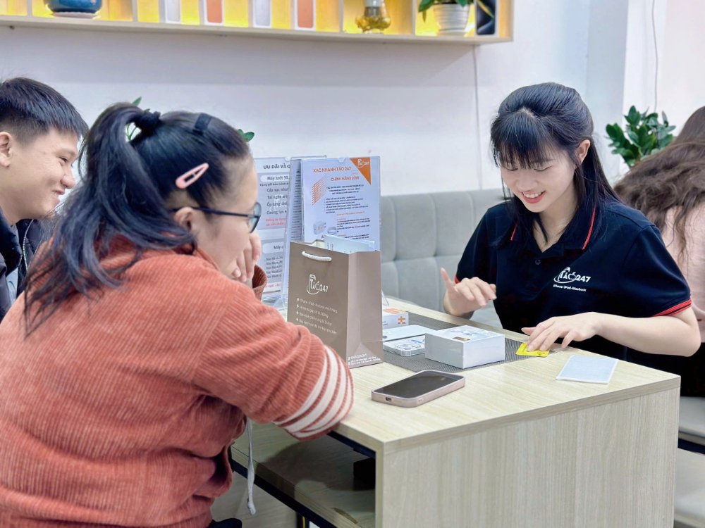 nhân viên Táo 247 thay pin iPhone XS Max cho khách hàng tại Đà Nẵng