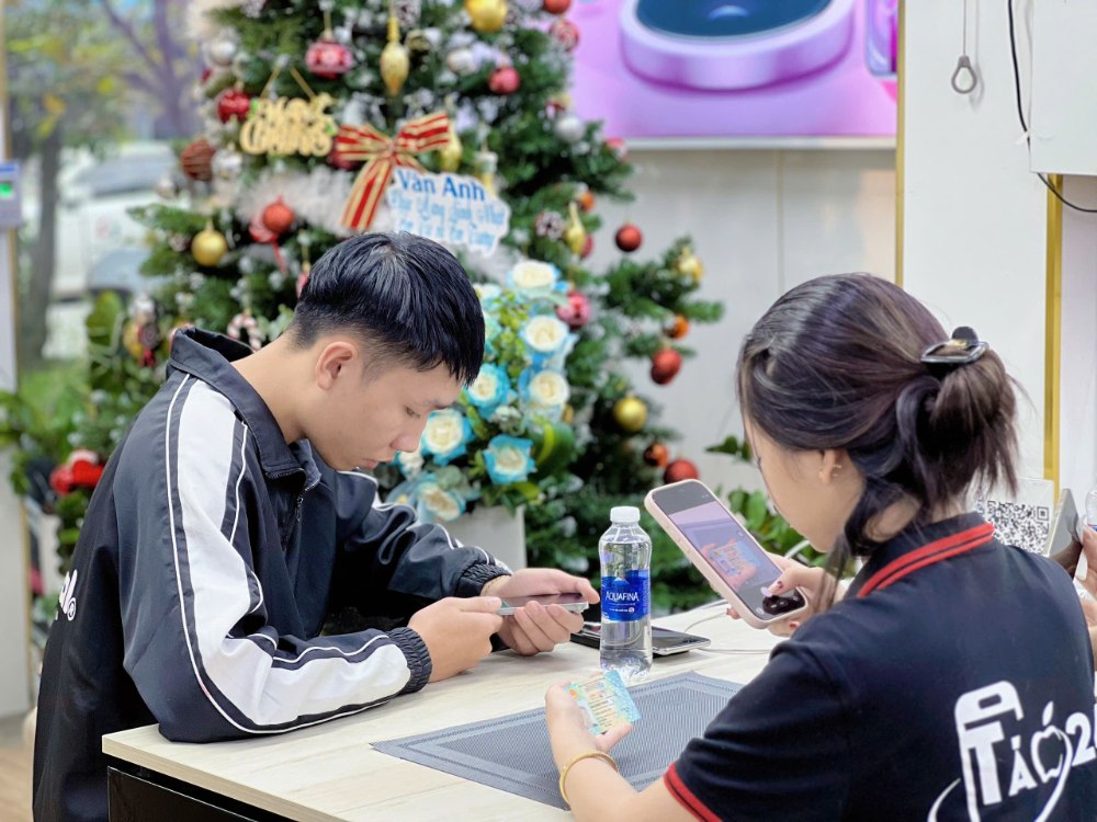 Nhân viên Táo 247 Hồ Chí Minh hỗ trợ khách test iPhone cũ zin 100% tại cửa hàng Gò Vấp