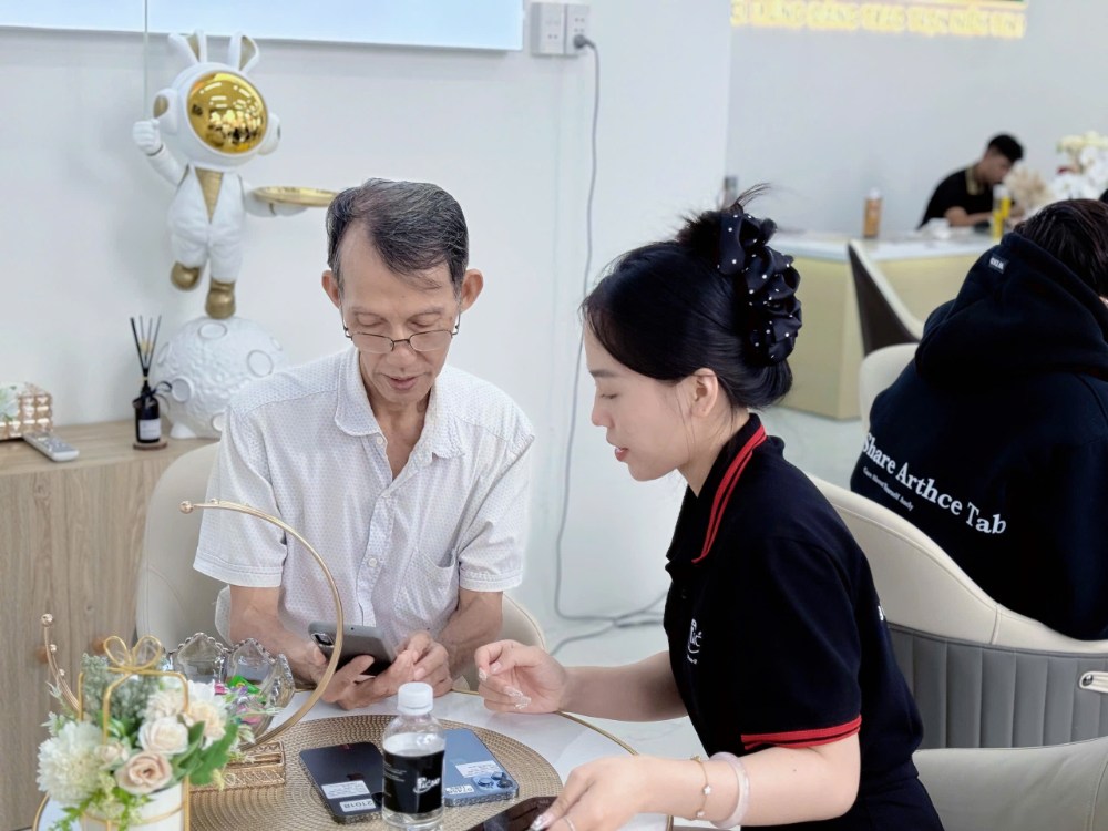 Nhân viên Táo 247 HCM hướng dẫn khách hàng sử dụng iPhone Like New chính hãng tại cửa hàng Gò Vấp