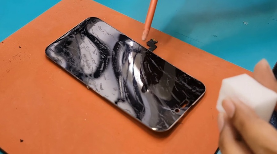 Kỹ thuật viên Táo 247 đang ép kính iPhone bị nứt, giữ nguyên màn hình zin, cảm ứng ổn định