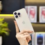 iPhone 14 Pro Max màu vàng Gold trên tay khách bên kệ trưng bày Táo 247