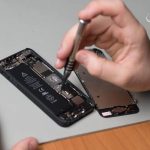 Kỹ thuật viên mở máy iPhone bằng tua vít để kiểm tra linh kiện bên trong