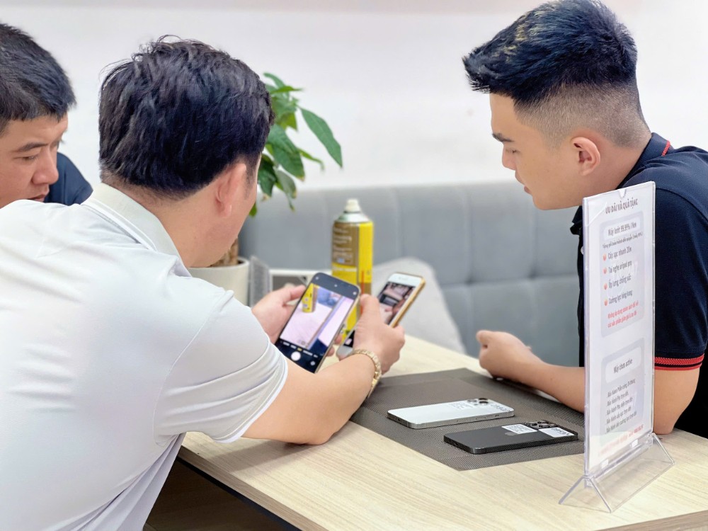 Nhân viên Táo 247 kiểm tra iPhone cùng khách tại cửa hàng