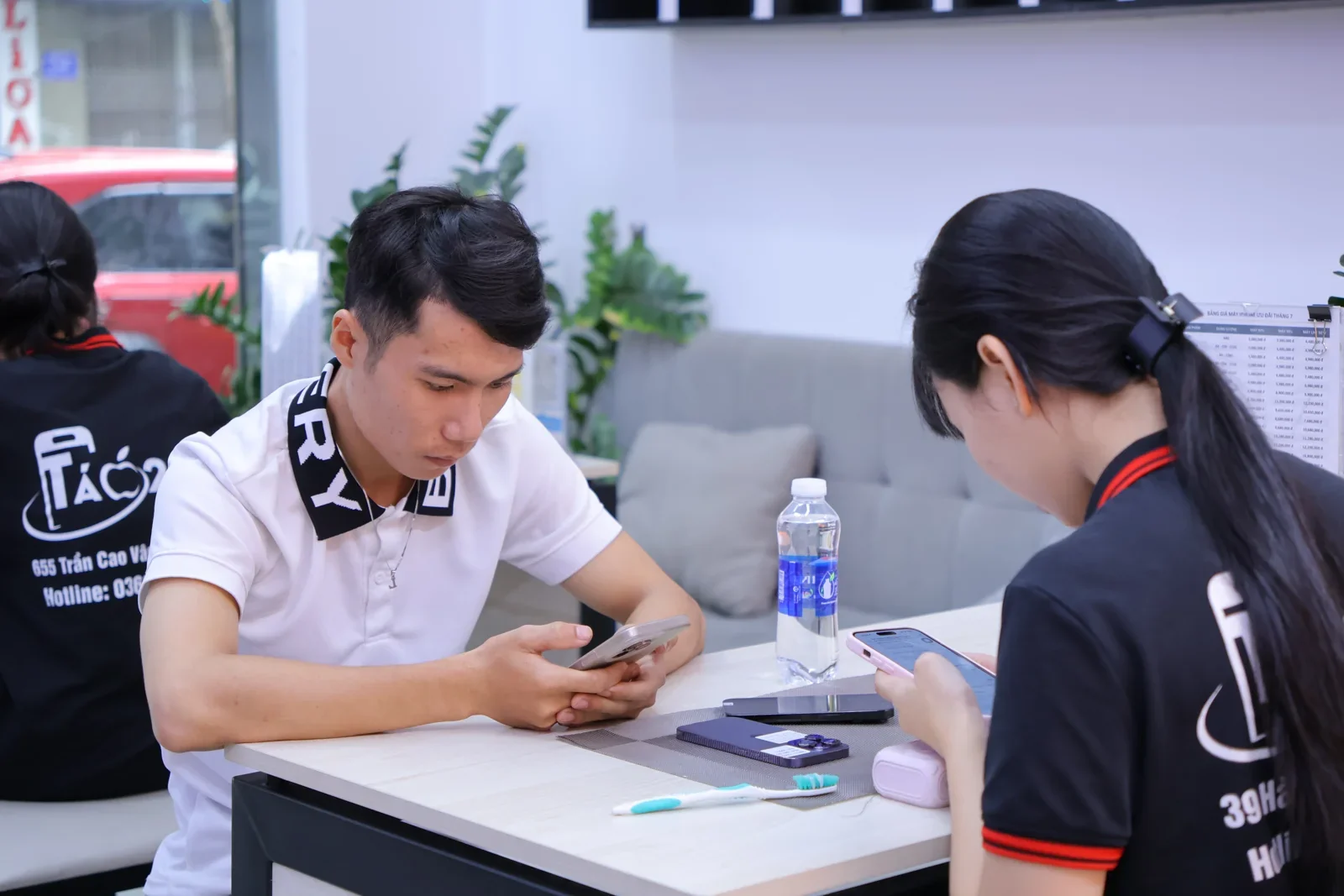 Khách nam tự kiểm tra iPhone, ngồi đối diện nhân viên Táo 247