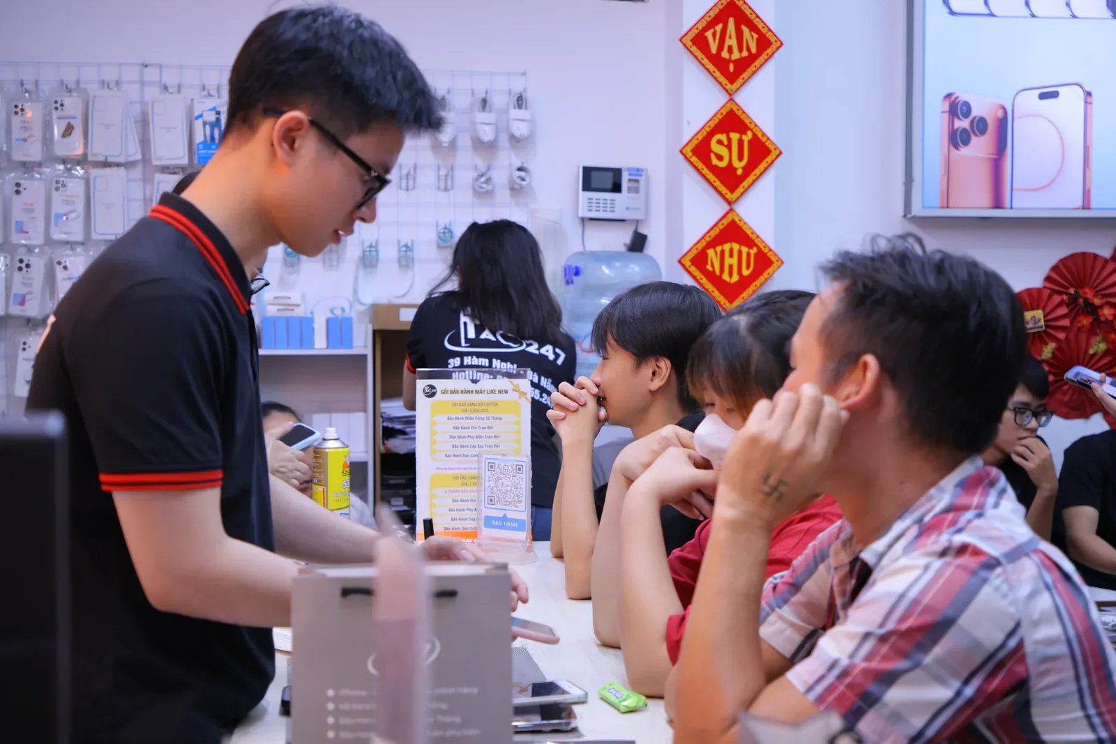 Khách ngồi chờ trước quầy trong lúc nhân viên Táo 247 xử lý máy