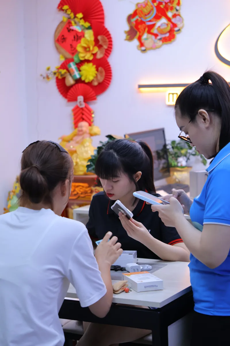 Khách nữ kiểm tra iPhone trước khi nhận máy tại Táo 247