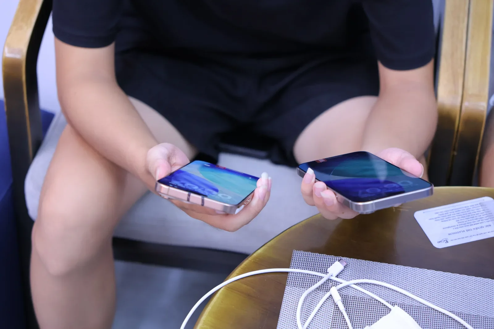 Khách cầm hai chiếc iPhone so sánh màn hình tại Táo 247