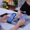 Khách và nhân viên Táo 247 cùng xem màn hình chính của hai chiếc iPhone trên bàn